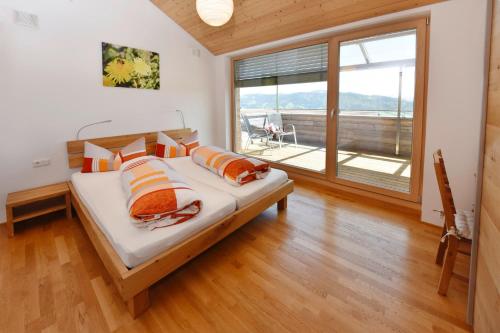 a bedroom with a bed and a large window at Ferienhof Feurle in Sulzberg