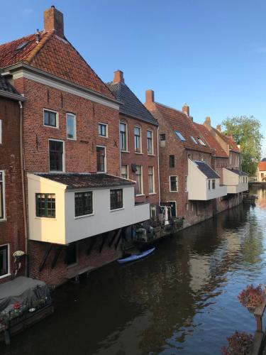 a group of buildings next to a river at De vijgenhof in Appingedam