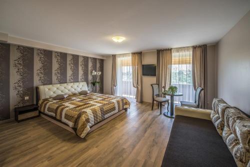 een slaapkamer met een bed en een bank bij Floros Simfonija in Šventoji