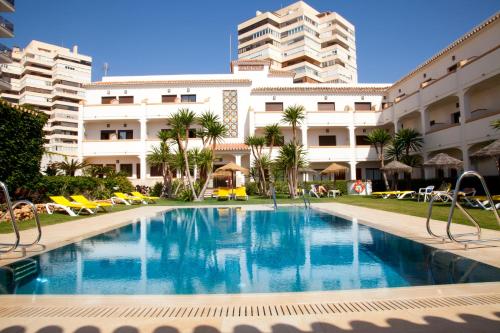 une piscine en face d'un bâtiment dans l'établissement Hotel Tarik, à Torremolinos