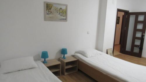 duas camas num quarto com dois candeeiros azuis em Apartment Crystal em Balchik