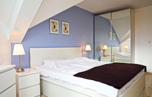 ダルウフコにあるApartament dwupokojowy Blue Skyの青い壁のベッドルーム1室(大きな白いベッド1台付)