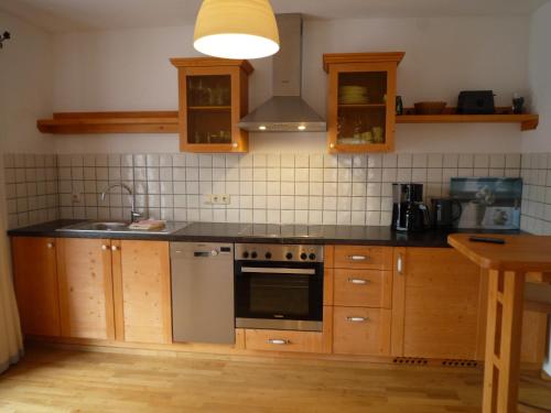 a kitchen with wooden cabinets and a stove top oven at Gästehaus Johanna in Bad Wiessee
