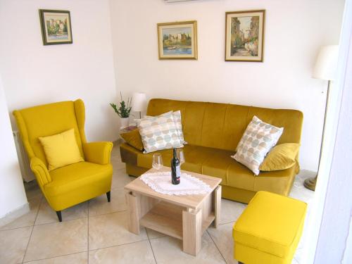 un soggiorno con 2 sedie gialle e un divano di Apartment Jan a Krk