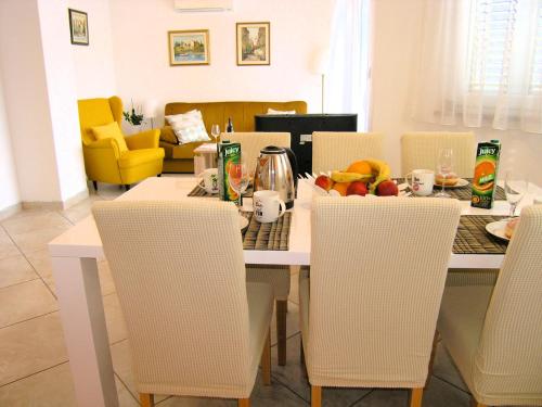una sala da pranzo con tavolo e sedie con frutta di Apartment Jan a Krk