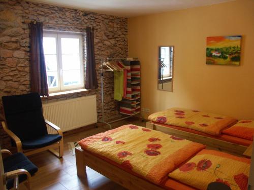 1 dormitorio con 2 camas, silla y ventana en Bed And Breakfast Isidorus, en Winterberg