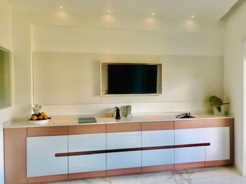uma cozinha com uma televisão de ecrã plano na parede em S'O Suites Tropea em Tropea