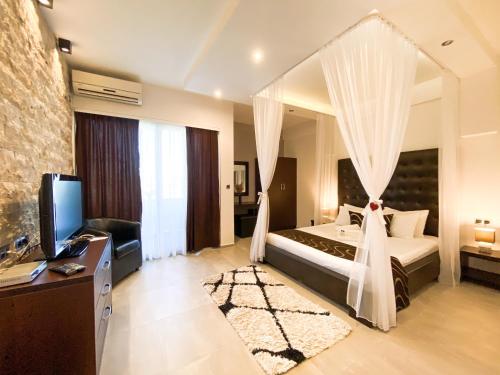 a bedroom with a bed with curtains and a television at RESIDENCE Apartments in Ulcinj