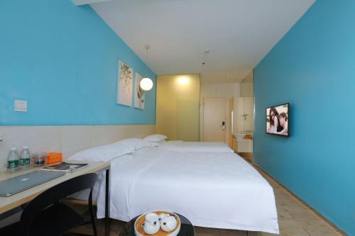 Schlafzimmer mit einem großen weißen Bett und einem Schreibtisch in der Unterkunft Colour Inn - She Kou Branch in Shenzhen