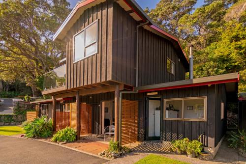 a house with a black and wooden facade at Anglers Lodge in Coromandel Town