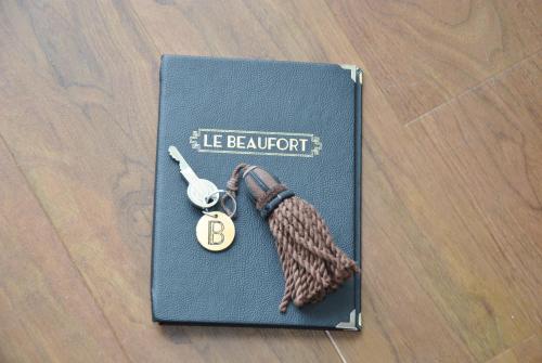 a book with a key and a tie on it at Hôtel Le Beaufort in Saint Malo