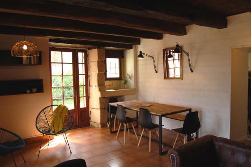 uma sala de estar com uma mesa de madeira e cadeiras em LOU CLEDOU em Cendrieux