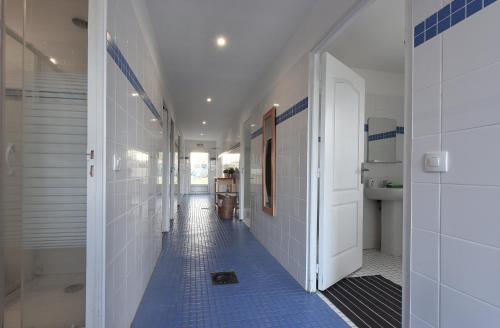 a hallway with blue tiles on the floor of a bathroom at Yourte Nomade-Lodge in La Chapelle-Gauthier