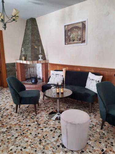 a living room with a couch and chairs and a fireplace at La Bonne Auberge in Ségny
