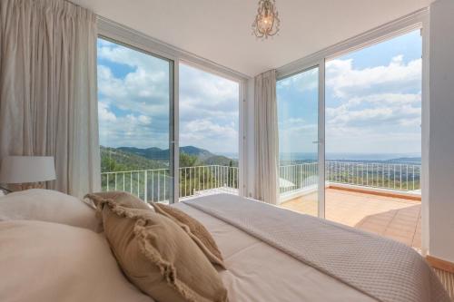 1 dormitorio con 1 cama frente a una ventana grande en Rent this Luxury Villa with Amazing Sea Views, Ibiza Villa 1021, en Sant Josep de sa Talaia