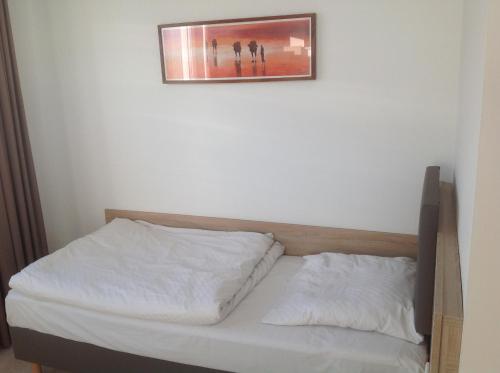 a bed in a room with a picture on the wall at Hotel Rodgau in Rodgau