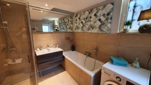 ein Bad mit einer Badewanne, einem Waschbecken und einer Dusche in der Unterkunft Ferienhaus Elbsandstein-Chalet in Bad Schandau