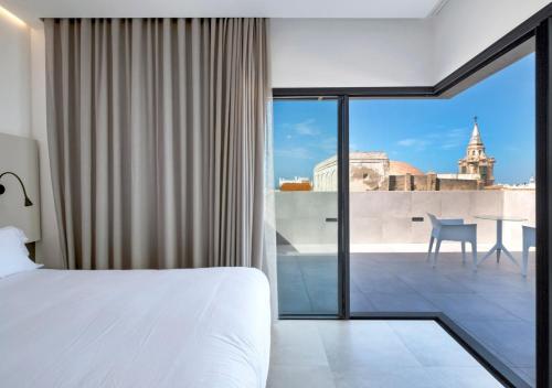 a bedroom with a bed and a view of the city at Dormos Hotel in Cádiz