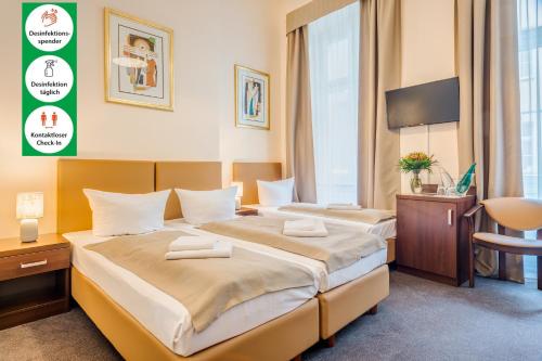 ベルリンにあるアッパー ルーム ホテル クアフュルステンダムのベッド2台とテレビが備わるホテルルームです。