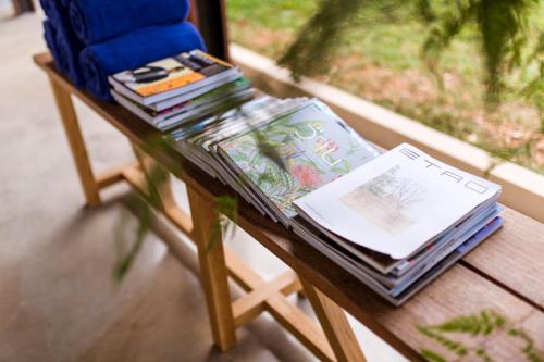 a table with books on it next to a chair at Roukh Kiri Khaoyai, The Centara Collection in Pak Chong
