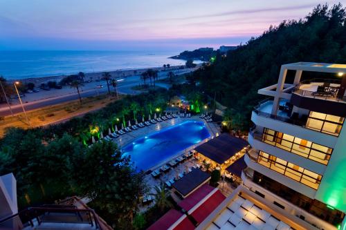 um hotel com piscina e praia à noite em Miarosa İncekum Beach em Avsallar