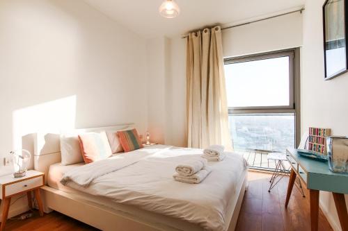 a bedroom with a large bed with towels on it at Luxury Condo & Spectacular View by FeelHome in Tel Aviv