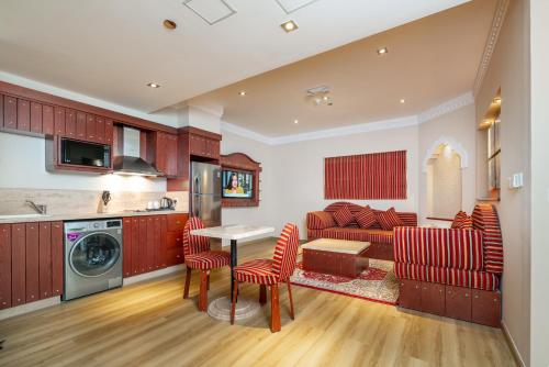 uma cozinha e sala de estar com mesa e cadeiras em Al Liwan Suites Rawdat Al Khail em Doha