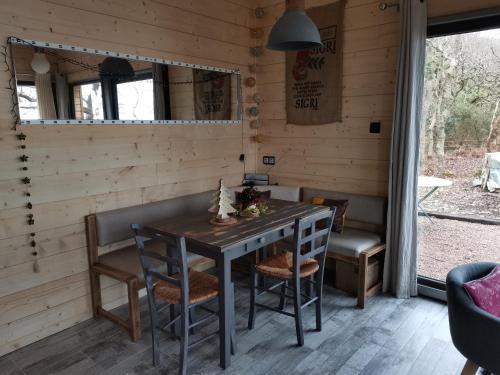 DigosvilleにあるAu courtil des chênes marins, meublé 3 étoilesのテーブルと椅子のあるダイニングルーム