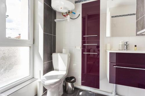 uma casa de banho com um WC, um lavatório e uma janela em CMG Porte de Châtillon - Malakoff V em Malakoff