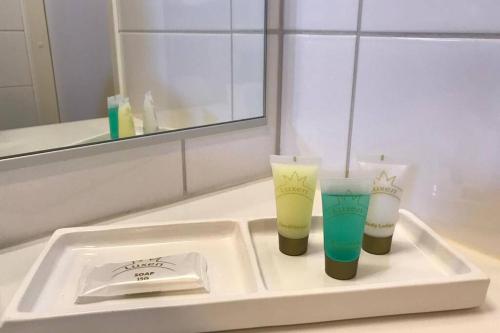 two cups sitting on a tray in a bathroom sink at Casa Verde nearby Helsinki airport in Vantaa