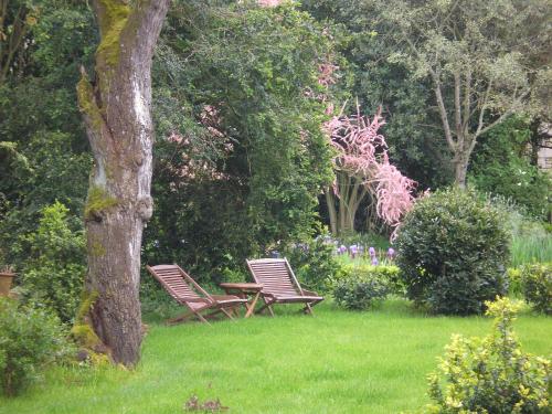 two chairs and a picnic table in a garden at Manoir de Boisairault in Le Coudray-Macouard