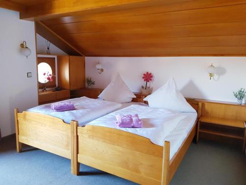 a bedroom with a bed with pink pillows on it at Ferienhaus am Höldersberg in Sonthofen