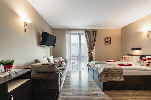 a hotel room with a bed and a couch at Pieninski Mak. in Szczawnica