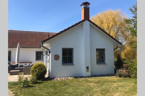 a white house with a grass yard at Gartenvilla@Baltic-Chalets in Warnkenhagen