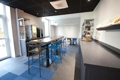 a kitchen with a table and chairs in a room at Hôtel Albert Elisabeth Gare SNCF in Clermont-Ferrand