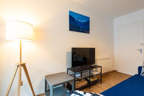a living room with a bed and a table and a lamp at Appartement Terrasse - Télécabine 2min - Thermes 4min - Tout équipé in Cauterets