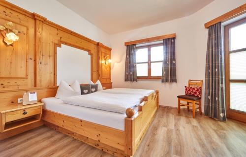 Schlafzimmer mit einem Bett, einem Schreibtisch und Fenstern in der Unterkunft Ferienhaus Magdalena in Mittenwald