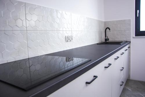 a kitchen with a sink and white tiles at WILLA KORSARSKA in Władysławowo