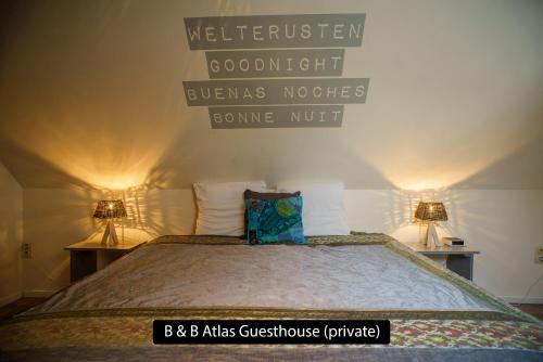 a bedroom with a bed with two lamps on two tables at Atlas Private Guesthouse in Bruges