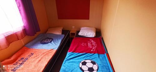 - 2 lits dans une chambre avec un ballon de football dans l'établissement Mobil-home au pied des Pyrénées, à Castillon-en-Couserans