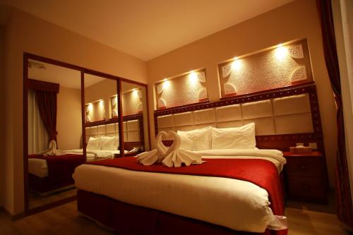 a hotel room with a bed with a towel on it at Al Liwan Suites Rawdat Al Khail in Doha