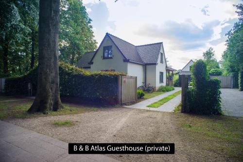 a white house with a fence and a driveway at Atlas Private Guesthouse in Bruges