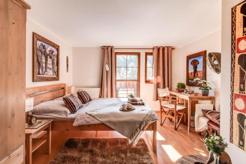 a bedroom with a bed and a desk and a table at Africa House in Zlín