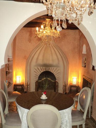 a dining room with a table and a chandelier at Riad Palais Des Princesses & Spa in Marrakesh