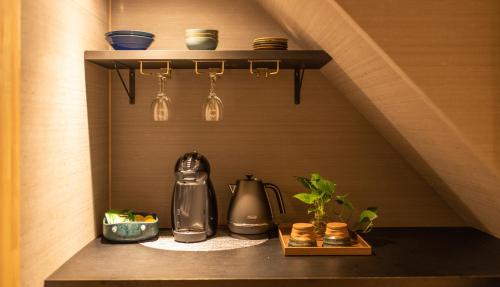 a shelf with a tea kettle and glasses on it at TABITABI STAY HIGASHIYAMA in Kyoto