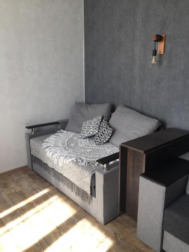 a small bedroom with a bed and a bench at Однокімнатна квартира-студія біля парку Шевченка in Ivano-Frankivsk