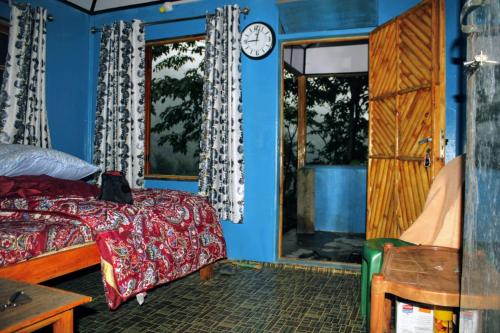 1 dormitorio con 1 cama y reloj en la pared en Vamoose Sampang, en Mangpu