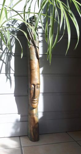 a vase with a face on it next to a plant at L'Oustaou du Bodo in Ambon