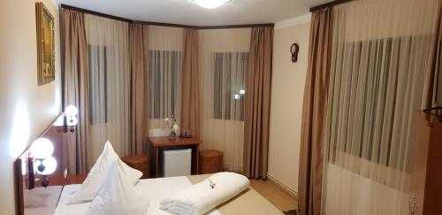 a hotel room with a bed and a window at Complex Turistic Caprioara in Baia Mare