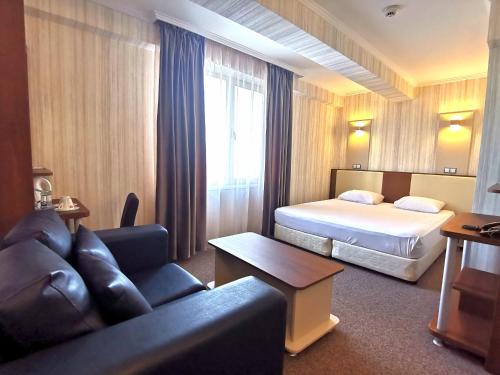 a hotel room with a bed and a couch at Elate Plaza Hotel in Sofia